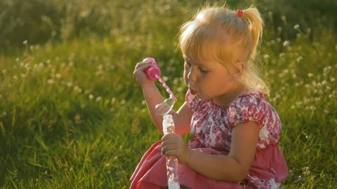 Little girl playing with soap bubbles outdoor Stock Footage