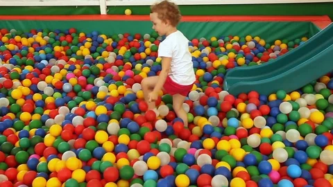 Little girl plays in the pool with spheres Stock Footage