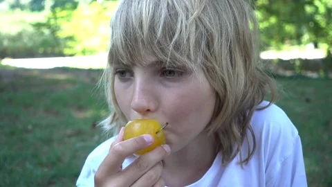 Little Girl portrait eating Aliche in a Park Stock Footage