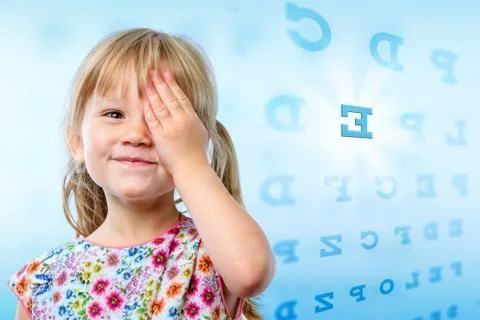 Little girl reading eye chart. Stock Photos
