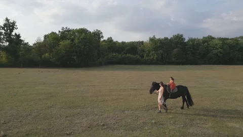 Little girl riding black horse in a fiel... | Stock Video | Pond5