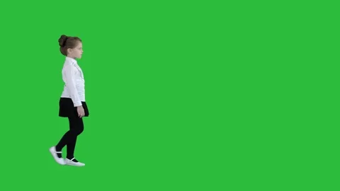 Little girl in school uniform walking by on a Green Screen, Chroma Key. Stock Footage