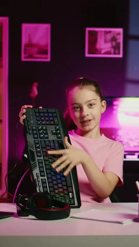 Little girl showcasing computer peripherals to fans on gen Z online channel Stock Footage 255595049