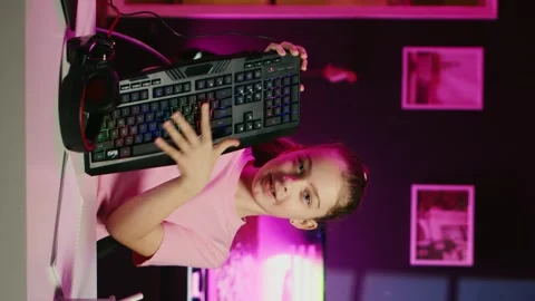 Little girl showcasing computer peripherals to fans on gen Z online channel Stock Footage 256516367
