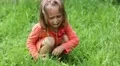 Little girl sits on green grass and crying HD Footage