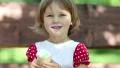 Little girl sits on the swing bench and eats ice cream HD Footage