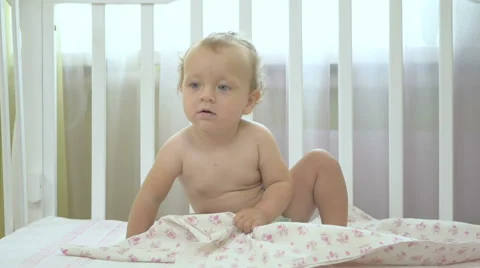 Little girl sitting in a baby cot. Stock Footage