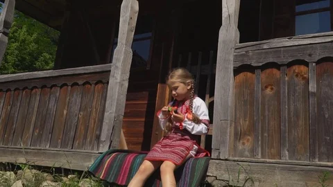 Little girl is sitting on the porch of the house Stock Footage