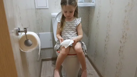 a little girl sitting on the toilet, the... | Stock Video | Pond5 