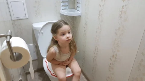 a little girl sitting on the toilet, the... | Stock Video | Pond5 