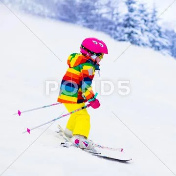 Little girl skiing in the mountains Stock Photos