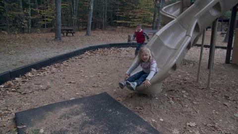 Little girl slides down a large slide Stock Footage 81537726