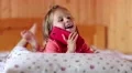 Little girl with smartphone lies on the bed HD Footage