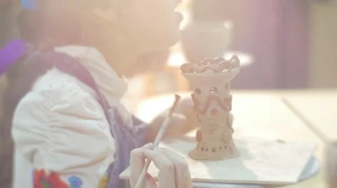Little Girl is Smiling And Glazing a Clay Figurine Tower Painting with Brush Stock Footage 59125157