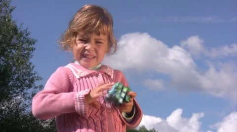 Little girl solves puzzle cube with earth pattern. Stock Footage 4357609