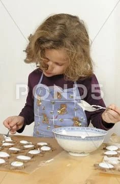 Little Girl Spreading Cinnamon Stars With Sugar Icing