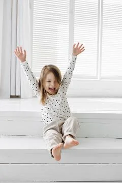 A little girl standing in front of a window Stock Photos