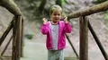 Little girl stands on a wooden bridge and does dance moves HD Footage