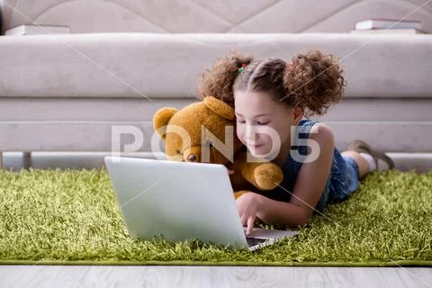 Little girl surfing internet on laptop Stock Photos
