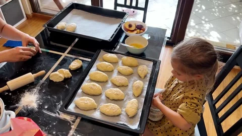 Little girl at table using kitchen ingredients and cookware to make cookies Video stock 267082710