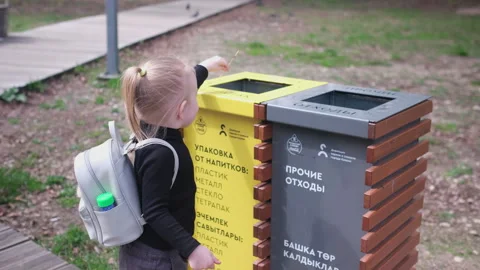 Little girl throws trash into a bin. Bins with waste sorting Stock Footage 278089901