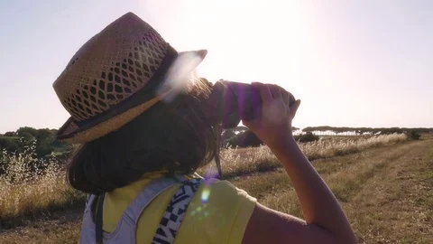 Little Girl Using Binoculars in open field looking around for directions Stock Footage 78113003