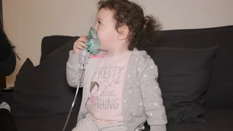 Little girl using inhaler. Medium shot. Stock Footage 123442423