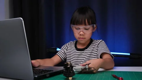 Little girl using laptop to write code and solve engineering problems at home. 스톡 동영상 237498310