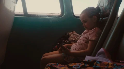 Little girl using smartphone while travelling in an old passenger boat in 4K Video stock 103221602