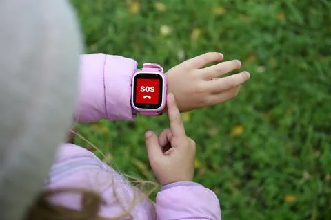 Little girl using SOS function on smartwatch outdoors, closeup Stockfoto's