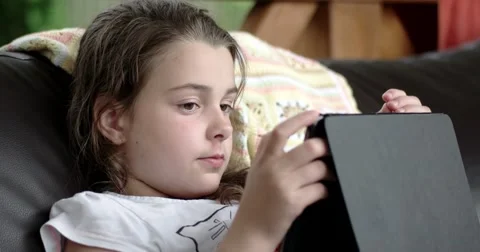 Little Girl Using Tablet Computer on Sofa on Terrace 動画素材 64655762
