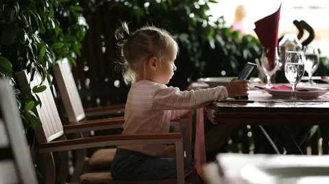 Little girl using tablet PC in a restaurant Stock Footage 52537361