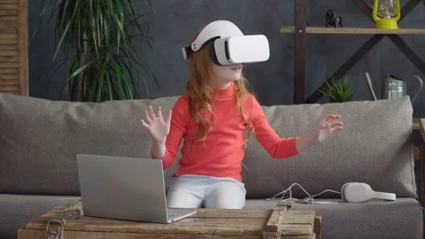 Little girl using virtual reality glasses on sofa Stock Footage 74543734