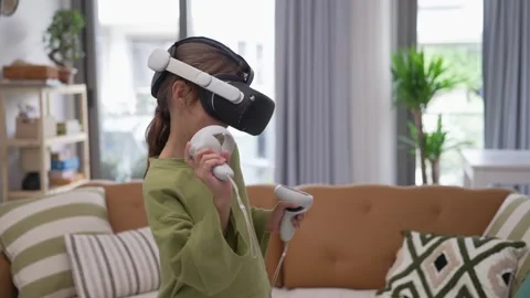 A Little Girl is Using a Virtual Reality Helmet Stock Footage 246126367