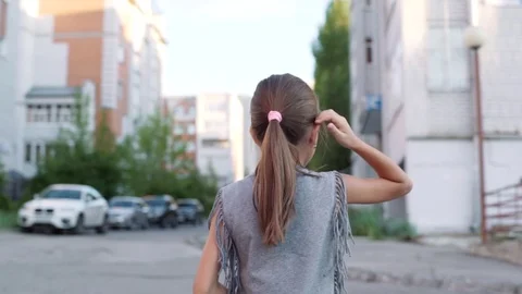 Little girl is walking along the street Stock Footage