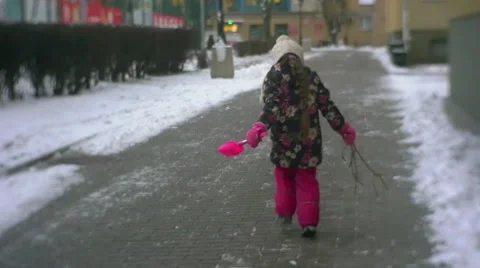 Little Girl is Walking Running Jumping on a Yard in Winter Slow Motion Holding Stock Footage 59771771