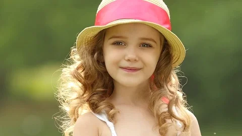 Little girl walks in the park looking into the distance and dreams. Slow motion Stock Footage 77591007