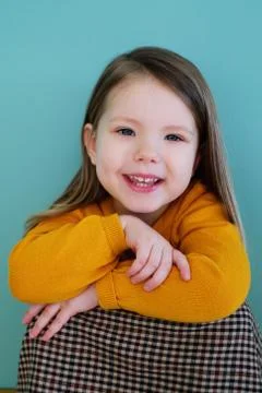 A little girl wearing a yellow shirt Stock Photos