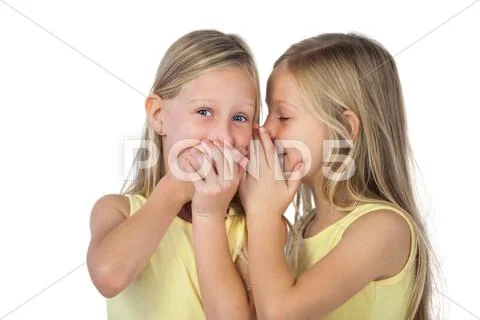 Little girl whispering to her sister Stock Photos