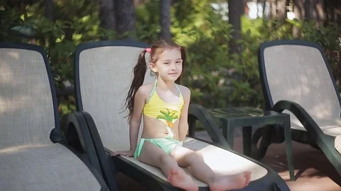 A little girl in a yellow bathing suit i... | Stock Video | Pond5 