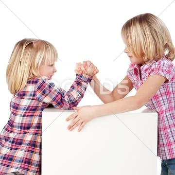 Little girls arm wrestling against white background Stock Photos
