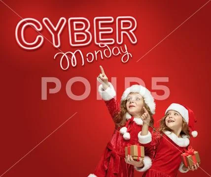 The little girls in Santa hat with gifts Stock Photos