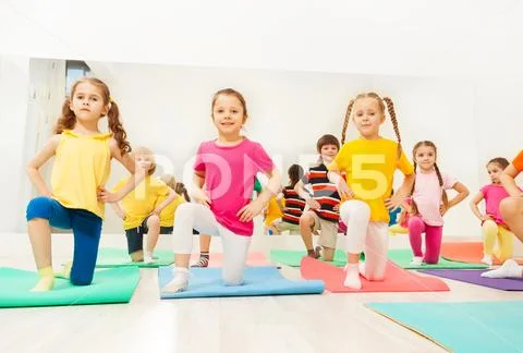 Little girls standing on knee in fitness class Stock Photos