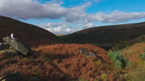 Little guy on a vast rock, deep in thought. Aerial video rotates slowly ove.. Видео 254163897