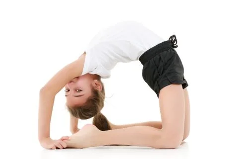 The little gymnast performs a bridge. Stock Photos