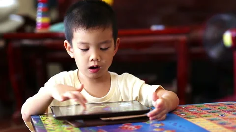 Little handsome boy touch on ipad tablet and playing game at home Stock Footage 47262075