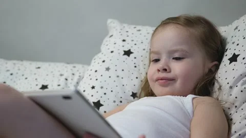Little happy baby is playing tablet whil... | Stock Video | Pond5