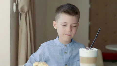A little happy boy is getting ready to try a delicious dessert. The child smiles Stock Footage 154424725