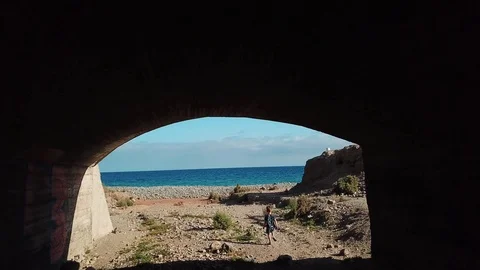Little happy boy is running through arch to the ocean. Camera follows a kid who Stock Footage 94124037