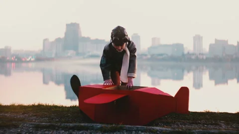 Little happy pilot boy getting into fun red cardboard plane costume at amazing Video stock 99693138
